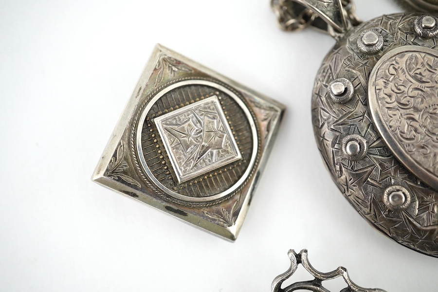 An oval engraved white metal enclosed locket and chain and five assorted white metal brooches. Condition - fair